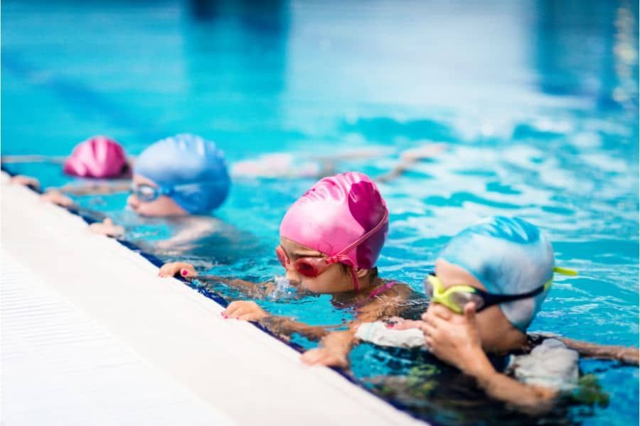 Children taking swimming lessons at summer camp
